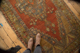 Vintage Anatolian runner featuring geometric medallion and spandrels in rich terra cotta and slate blue.