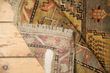 Vintage Anatolian rug runner, folded corner showing light natural fringe and woven foundation.
