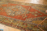 Close-up of geometric border motifs in slate blue and bronze on a vintage Anatolian rug.