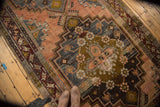 Distressed Anatolian runner's central medallion with faded terra cotta, navy, and bronze.