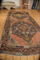 Distressed Anatolian rug runner corner showing geometric border, fringe, and faded terra cotta.
