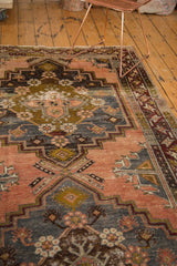 Distressed Anatolian runner showing stepped motifs in faded terra cotta, charcoal, and visible wear.