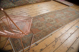 Distressed vintage Oushak runner with faded burnt orange medallions and rococo motifs.