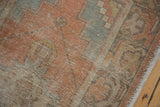 Vintage distressed Oushak runner showcasing faded burnt orange, slate blue, brown tones, and worn texture.