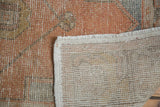 Tightly woven back, secured edge, and distressed burnt orange pile of a vintage Oushak runner.