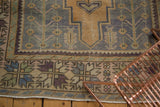 Distressed vintage Oushak rug border with rectilinear plant motifs and fringe.