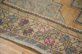 Distressed Oushak rug with dusty gold border, sage green, violet plant motifs.