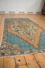 Stepped corner spandrel and border of a distressed Oushak rug, aqua blue, dusty gold tones.