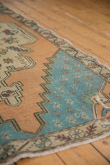Close-up of distressed Oushak rug's worn pale aqua blue field and stepped spandrel drawing.