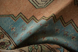 Distressed Oushak rug's textured pile, with pale aqua and dusty gold stepped border.