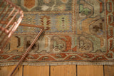 Vintage Distressed Oushak rug edge showing terra cotta floral border and soft green hues.