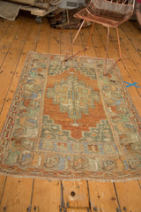 Distressed Oushak rug border and fringe with worn terra cotta and mint floral vinery.