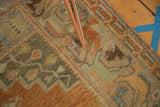 Distressed Oushak rug texture featuring terra cotta floral vinery and celadon green accents.