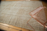 Faded vintage Oushak carpet revealing inherent worn texture in ivory, beige, and sand.