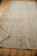 Secured edge of the distressed vintage Oushak rug, highlighting textured beige and ivory weave.