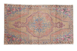 Distressed Oushak rug with roundel medallion, floral motifs, soft beige, blush, and slate blue.