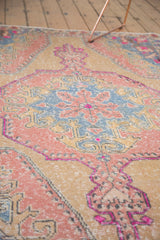 Distressed Oushak rug detail: blush roundel medallion, slate blue accents, fuchsia finials.