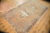 Distressed vintage Oushak rug, showing geometric patterns, terra cotta tones, and visible foundation.