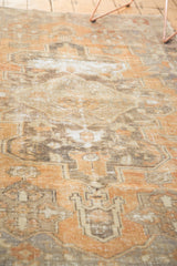 Distressed Oushak rug detail: geometric motifs with time-softened pile in terra cotta and brown.