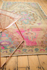 Vibrant pink and slate blue accents on the low, even pile of a distressed vintage Oushak rug.