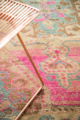 Evenly worn, low pile of a vintage Oushak rug showing bright pink and slate blue motifs.