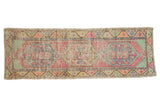 Distressed vintage Oushak runner with triple medallions, faded pink, blue, mint, and gold floral patterns.