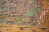 Textured pile and lively pink, blue, gold motifs on distressed Oushak runner corner.