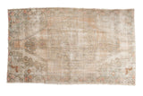 Vintage Distressed Oushak rug with faded peach, beige, and seafoam green floral medallion.