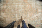 Distressed Oushak rug detail: faded peach, beige, subtle patterns, visible foundation.