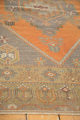 Olive, burnt orange, and charcoal geometric border of a vintage Oushak runner with fringe.