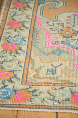 Vintage distressed Oushak rug detail: bright pink, sky blue, and terra cotta geometric and scrolling motifs.