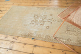 Faded ivory and pale coffee brown medallion with distressed pile texture.