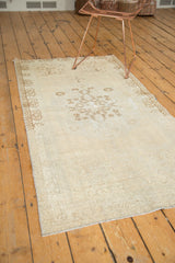 Distressed Oushak runner corner, revealing faded antique ivory tones and subtle brown pattern texture.