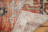 Distressed Oushak rug texture in cherry red, ivory, and charcoal, with visible hand-knotted reverse.