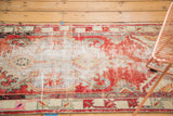 Distressed vintage Oushak runner with worn pile, showcasing faded cherry red, ivory, and soft blue.
