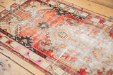 Faded cherry red, ivory, and grey tones on the distressed vintage Oushak rug pile.