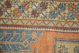 Faded tangerine and blue patterns on a distressed Oushak rug's low pile.