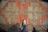 Distressed vintage Turkish Oushak runner, madder red field and stepped floral medallion.