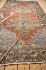 Distressed Oushak runner corner, revealing even wear and weeping willow motifs in madder red, slate blue, and beige.