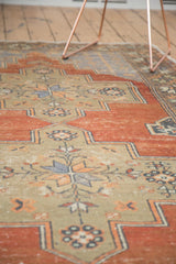 Distressed Oushak rug runner with even wear, showing madder red and blue floral motifs.