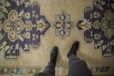 Vintage Oushak runner's ivory field with faded royal blue, pale bronze patterns, and abrashes.