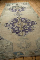 Vintage Oushak runner with faded royal blue, pale bronze medallion, and visible abrashes.