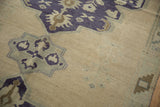 Faded royal blue and pale teal green geometric patterns on an Oushak rug's ivory field.