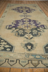 Detail of vintage Oushak rug: geometric medallion, border, and abrashes in faded purple and ivory.