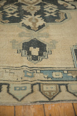 Geometric border with faded charcoal, pale teal, and ivory abrashes.