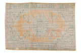 Distressed Oushak rug with dusty tangerine medallion, faded blue and mint green floral design. 6'1