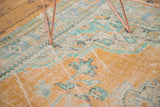 Distressed Oushak rug pile in tangerine orange, mint, with areas of exposed foundation.