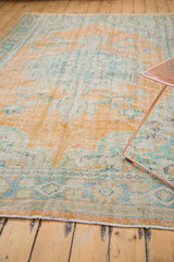 Distressed Oushak rug pile showing even wear, exposed foundation, and faded tangerine.