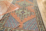 Distressed Oushak runner with celadon geometric medallion and blue boteh spandrel.