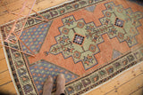 Distressed Oushak runner corner showing pale apricot field and blue boteh spandrel.